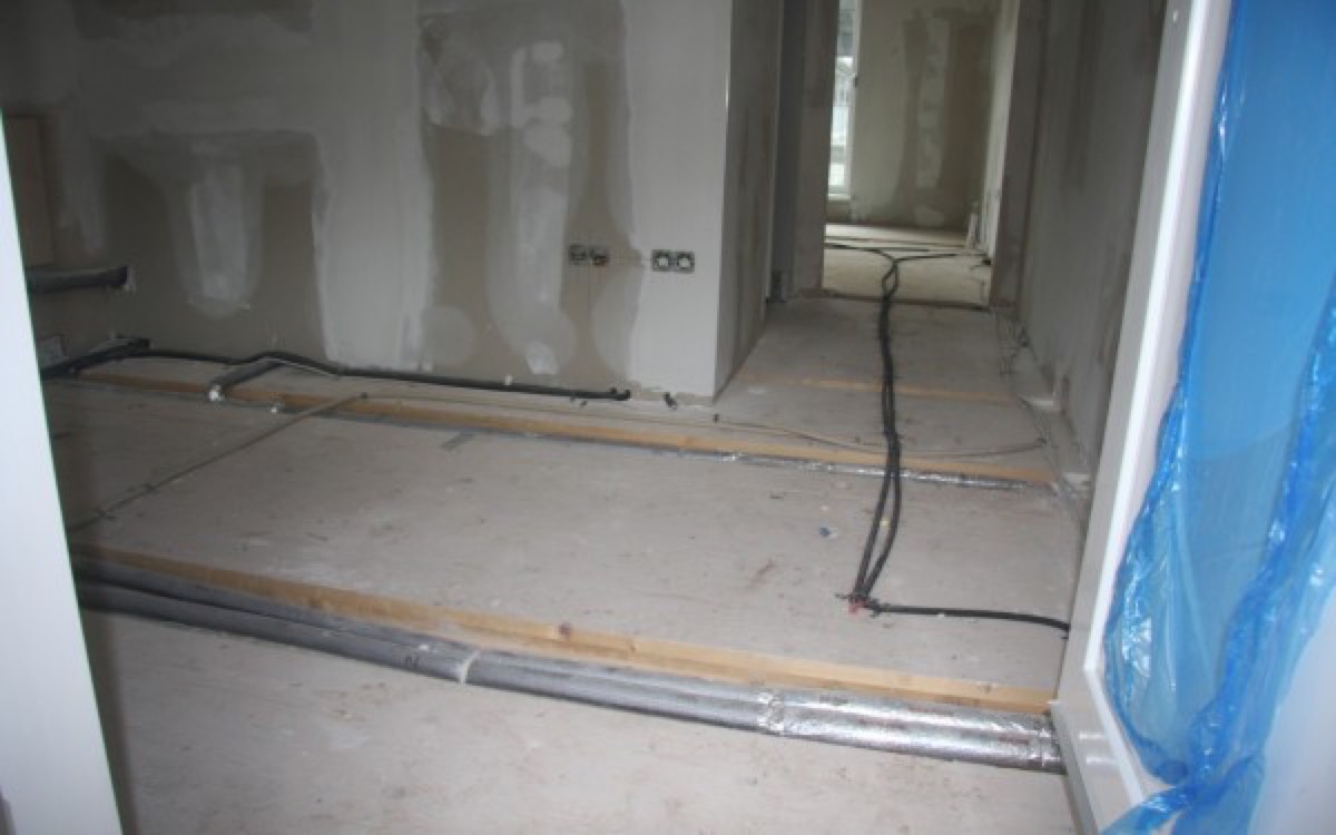 Typische Rohdecke mit auf der Decke liegenden Installationen vor dem Einbau